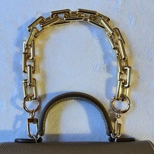 Gold Plastic Acrylic handbag chain with a metal clasp.